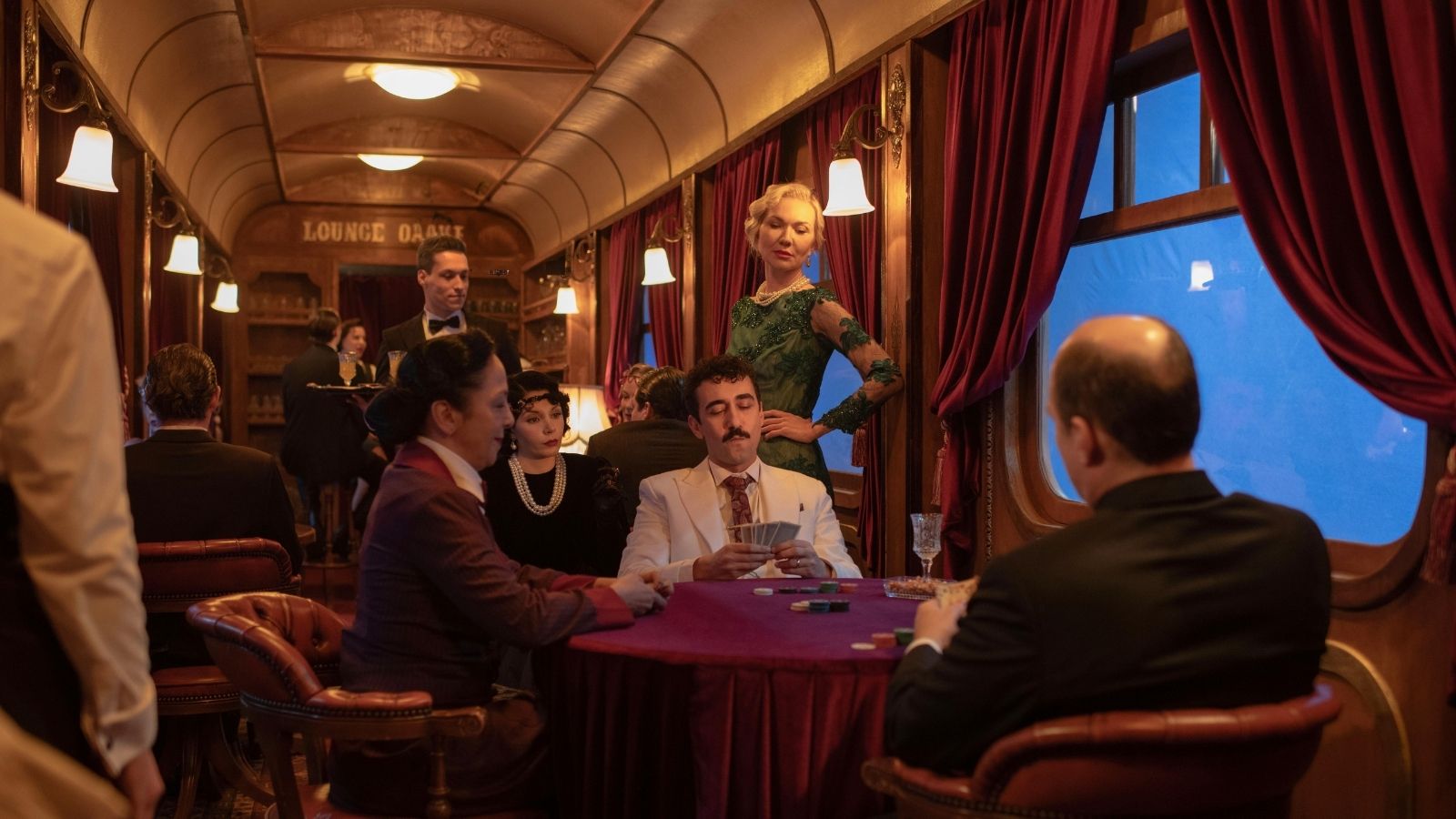 Lüks bir tren vagonunda dönem kostümleriyle geçen bir sahne.